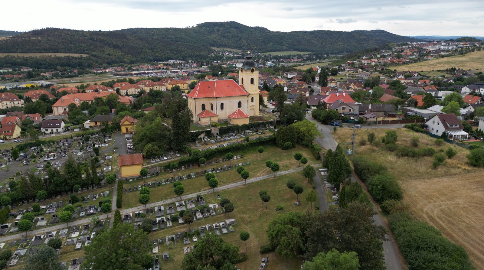 Surová fotka z dronu: kostel a město v zataženém letním dni