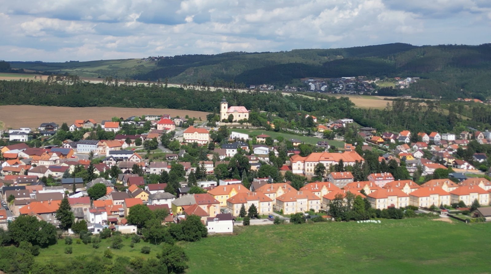 Surová fotka z dronu: panorama města s kostelem za běžného dne